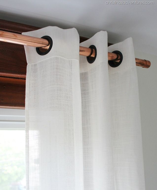 the curtains are hanging on the rod in front of the window with white drapes