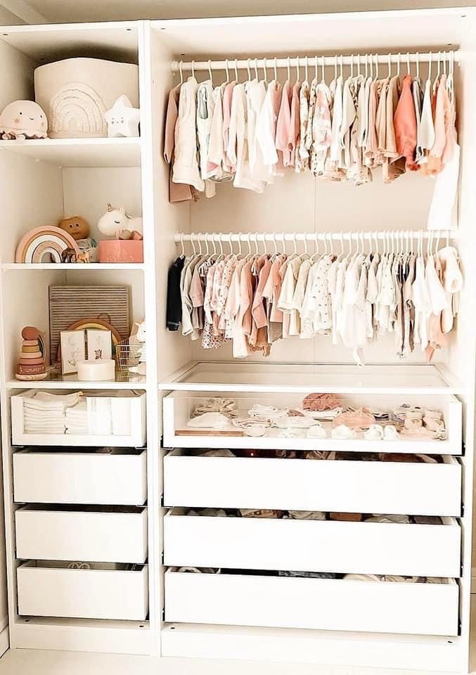 a white closet filled with lots of baby clothes