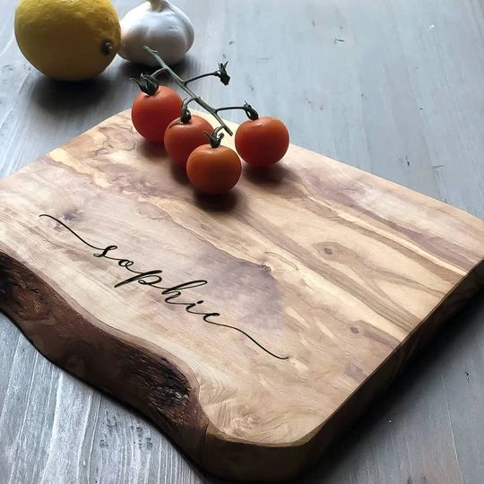 a cutting board with tomatoes on it next to some garlic and lemons in the background