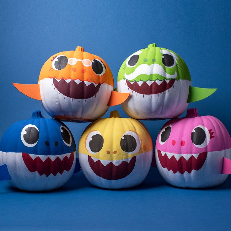 four pumpkins decorated to look like monsters with mouths and teeth on them, sitting in front of a blue background