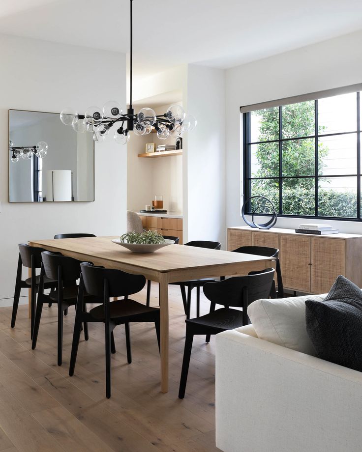 a dining room table with black chairs and a white couch