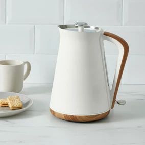 a white coffee pot and plate with crackers