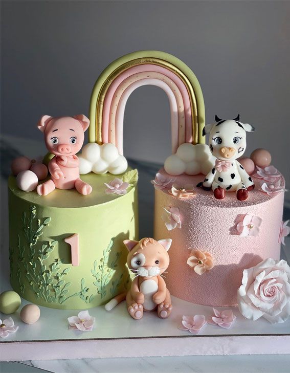 there are three cakes that have animals on the top one is pink, green and yellow