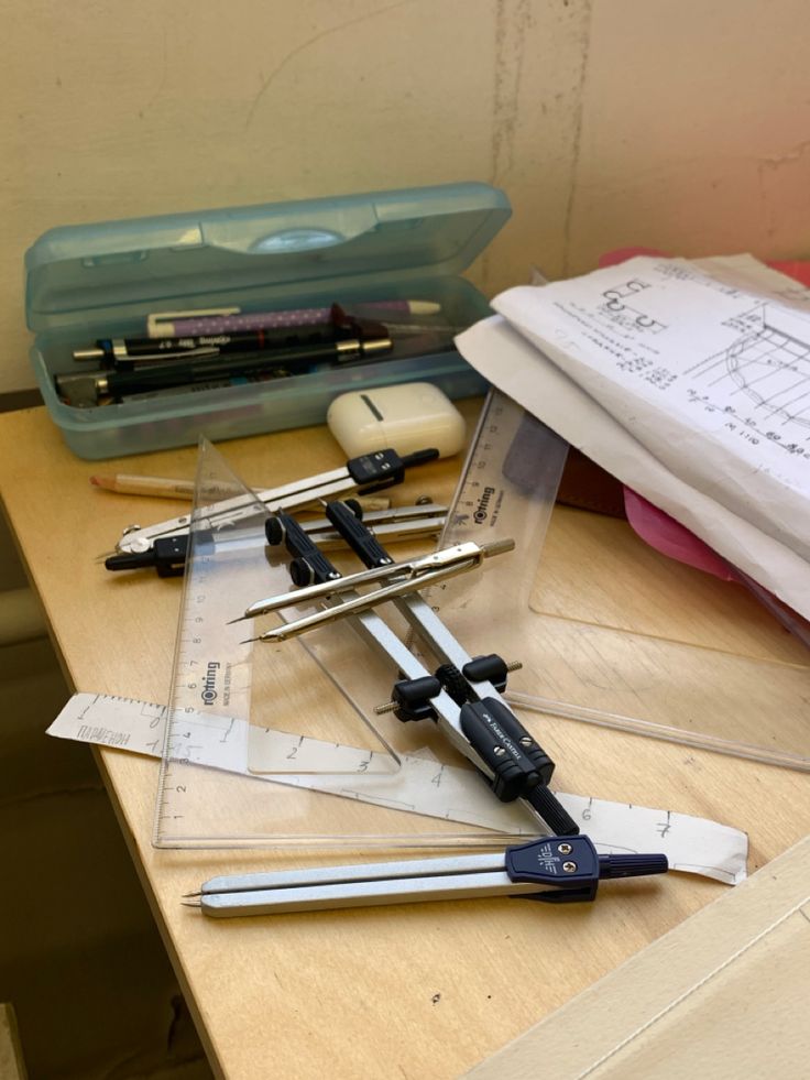 several tools are laying on top of a table with papers and pencils next to them