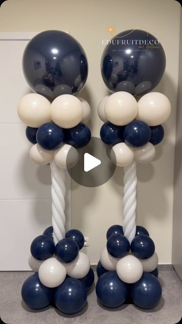 balloons and ropes are arranged in the shape of two columns with white and blue balls on them