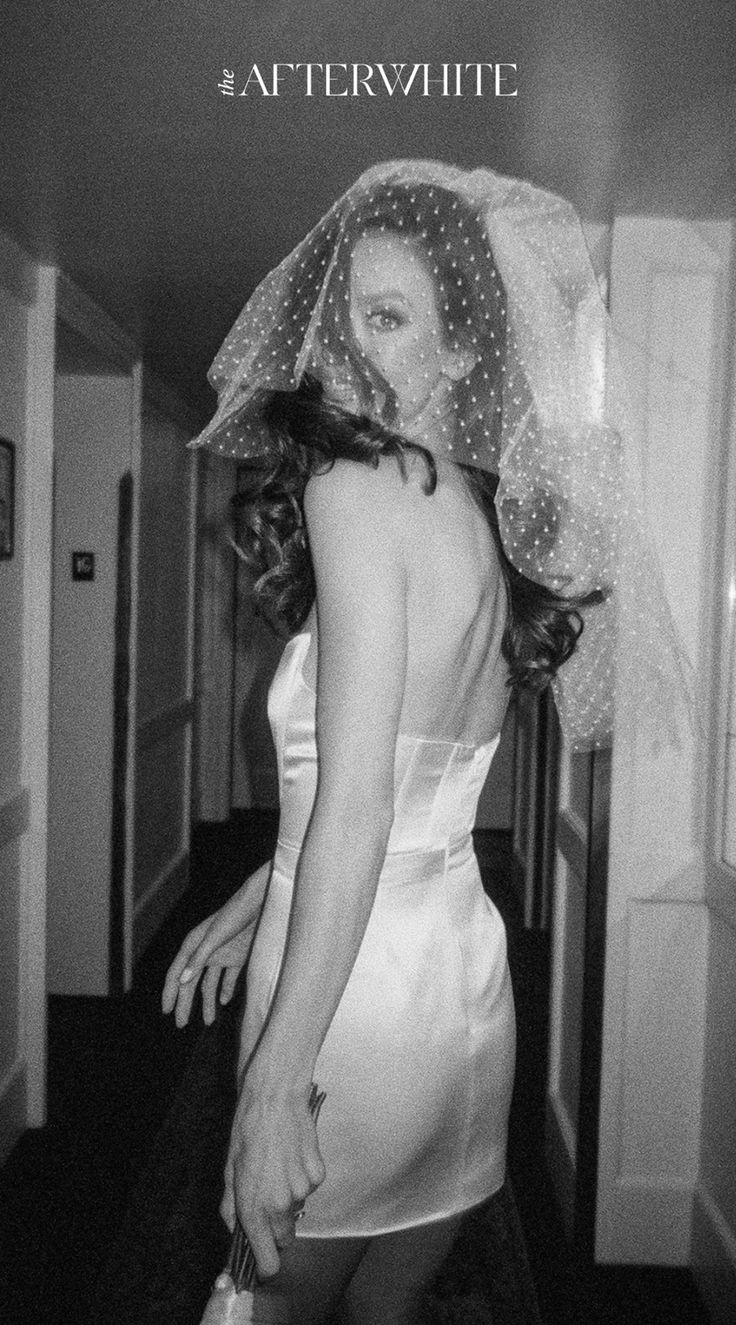 black and white photograph of a woman in a wedding dress with veil over her head