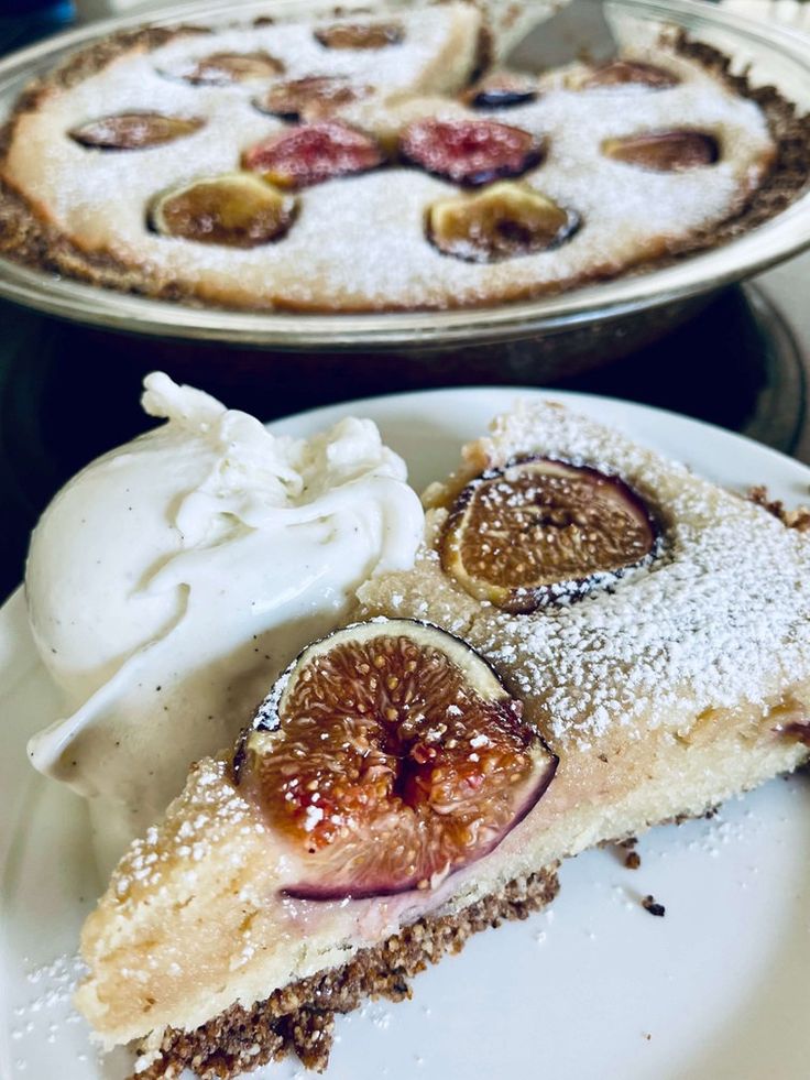 two pies on plates with whipped cream and fruit