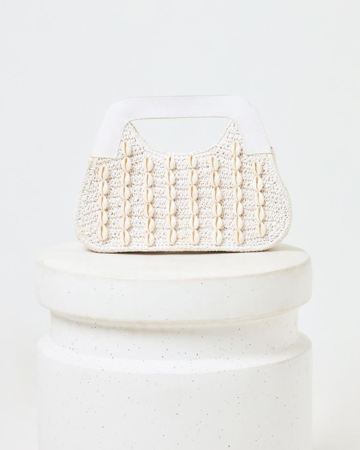 Seashells make everything better! The Miley Bag features a unique cowry shell pattern, magnetic closure and cotton-yarn body. It's also fully lined inside with a perfectly-sized pocket. cotton yarn clutch cowry shell pattern magnetic closing fully lined pocket inside Material: 100% Paper Style # LSMIL24 Everyday White Straw Pouch Bag, White Crochet Bag With Removable Pouch For Summer, White Top Handle Crochet Bag For Everyday Use, White Crochet Bag With Top Handle For Everyday, White Straw Bag With Removable Pouch, White Crochet Bag With Removable Pouch For Vacation, White Rectangular Clutch For Vacation, White Clutch Shoulder Bag For Vacation, White Crochet Handheld Bag With Braided Handles