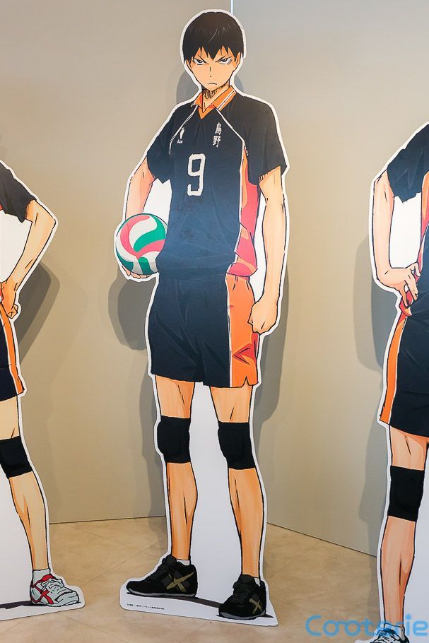 three cardboard cutouts of people in sports uniforms, one holding a ball and the other standing with his hands on his hips