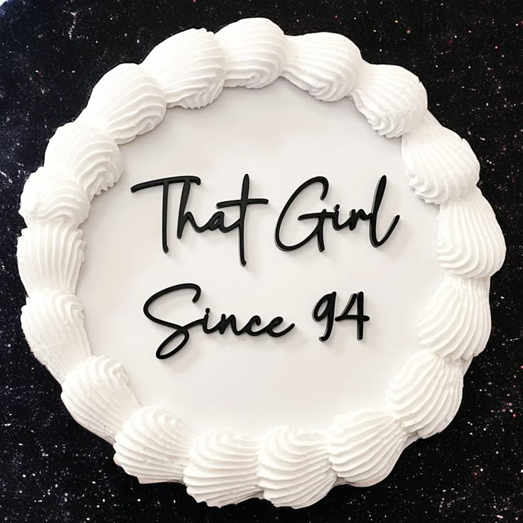 a cake with the words that girl since 94 written in black on it and surrounded by icing