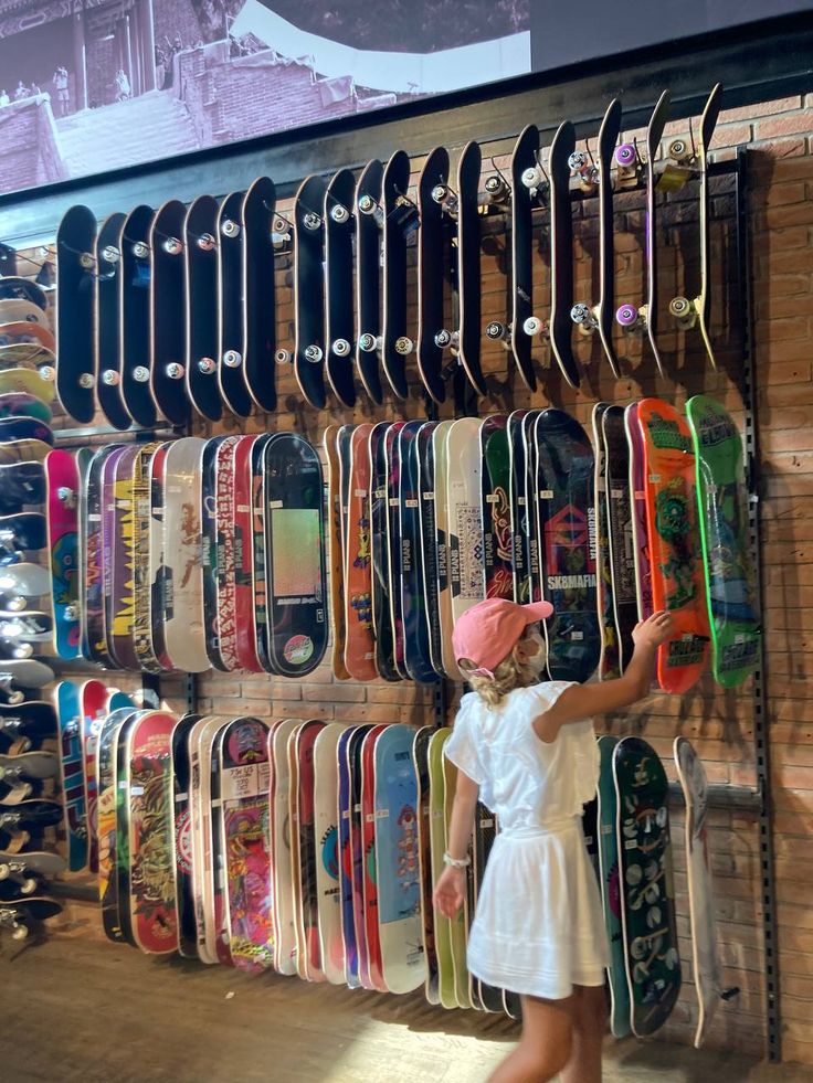 a woman standing in front of a display of skateboards