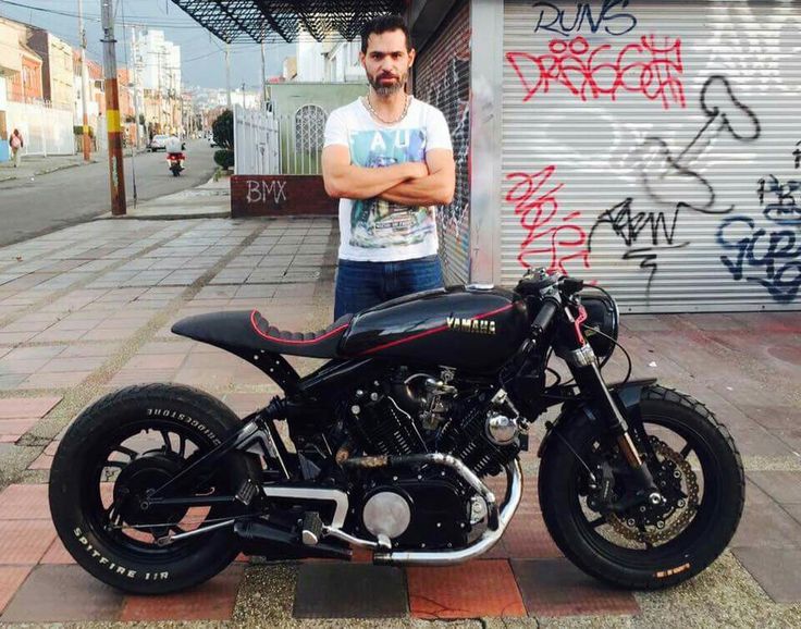 a man standing next to a parked motorcycle