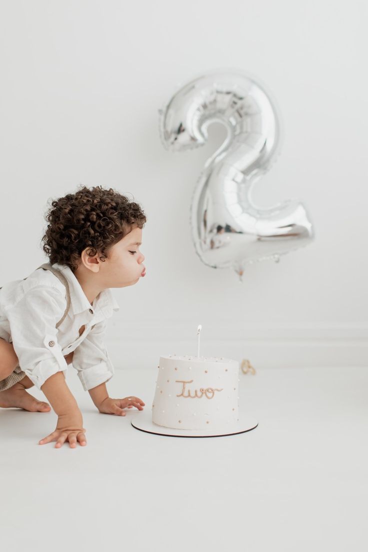 a little boy is blowing out the candles on his birthday cake