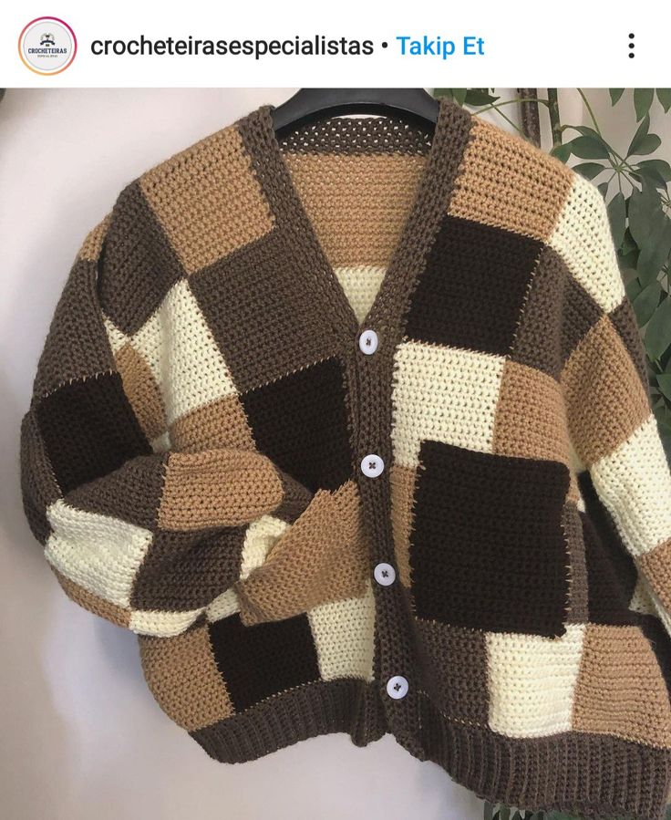 a brown and white sweater hanging on a hanger