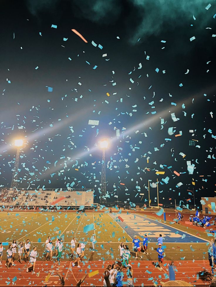 a group of people on a field with confetti in the air