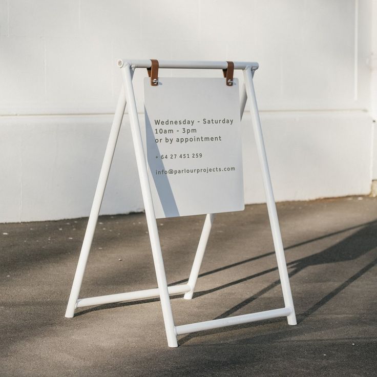 an open sign stands in front of a white building