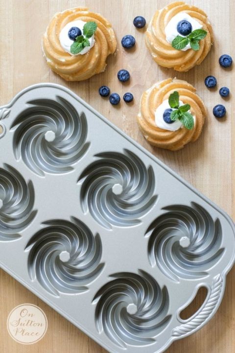 cupcakes with blueberries and mint sprinkles on a wooden table