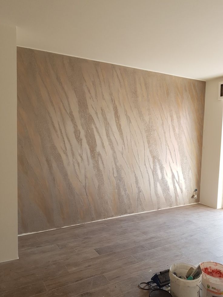 an empty room with wood flooring and walls painted white, in the process of being renovated