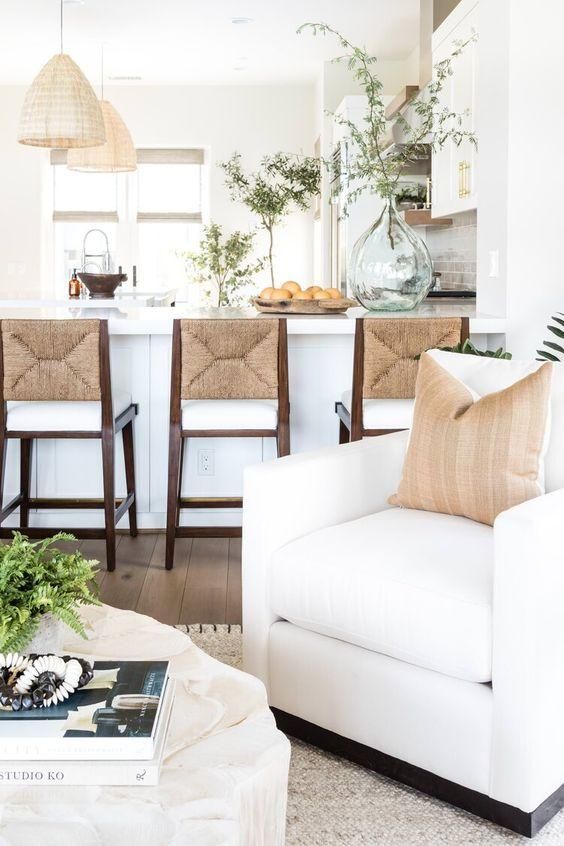 a living room filled with furniture and a kitchen in the backgroung area