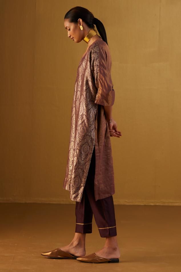 Plum kaftan made with handloom brocade and minimal hand embroidery. Comes with plum cigarette pant. Components: 2 Type Of Work: Floral Neckline: V Neck Sleeve Type: Three Quarter Fabric: Kurta: Brocade and Handloom tissue, Pant: Cotton Silk, Lining: Shantoon Color: Purple Other Details:  Lace trims 2 pockets in pant Partially elasticated waistband Length: Kaftan: 41 inches Pant: 36 inches Model height: 5ft 9inches, wearing size M Note: Dupatta worn by the other model is not for sale Disclaimer: Brocade Kaftan, Velvet Kurta, Two Piece Wedding Dress, Designer Outfits, Lace Trims, Indian Designer Outfits, Kurta With Pants, Velvet Pants, Silk Pants