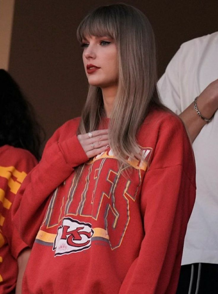 a woman with long hair wearing a red sweatshirt