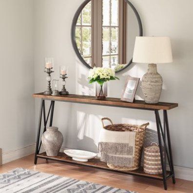 a wooden table topped with a mirror next to a vase filled with flowers and candles