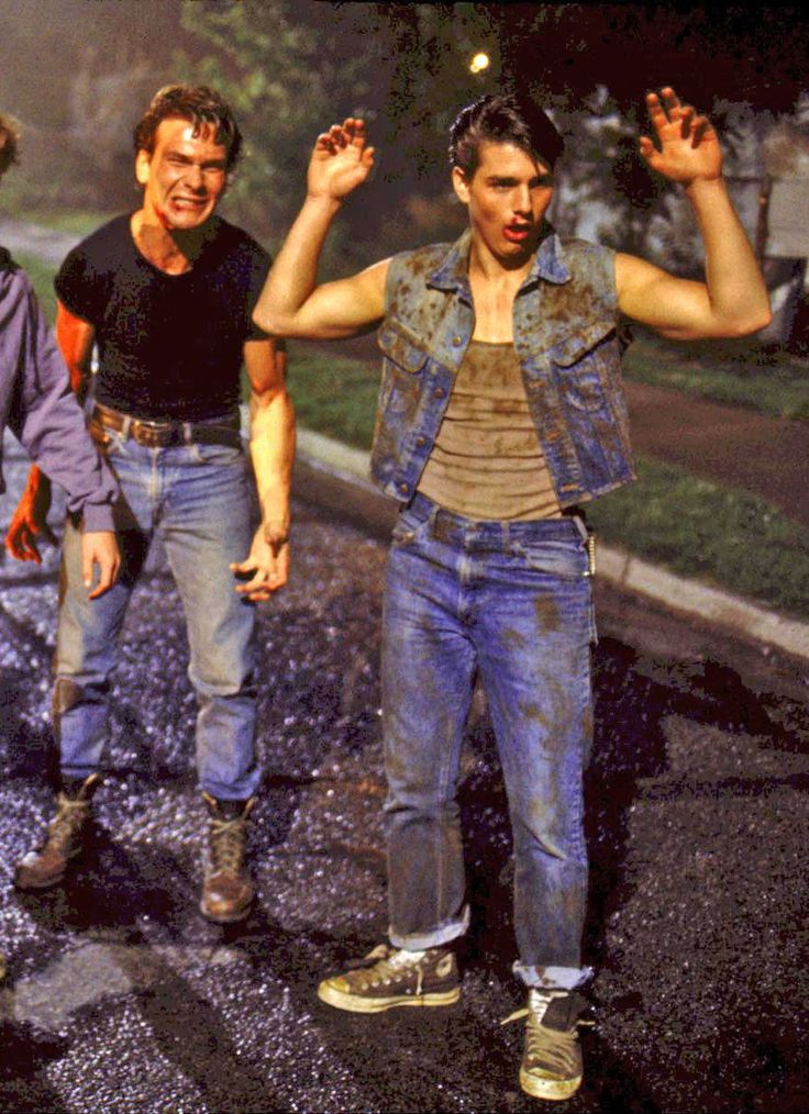 two men walking down the street with their hands in the air