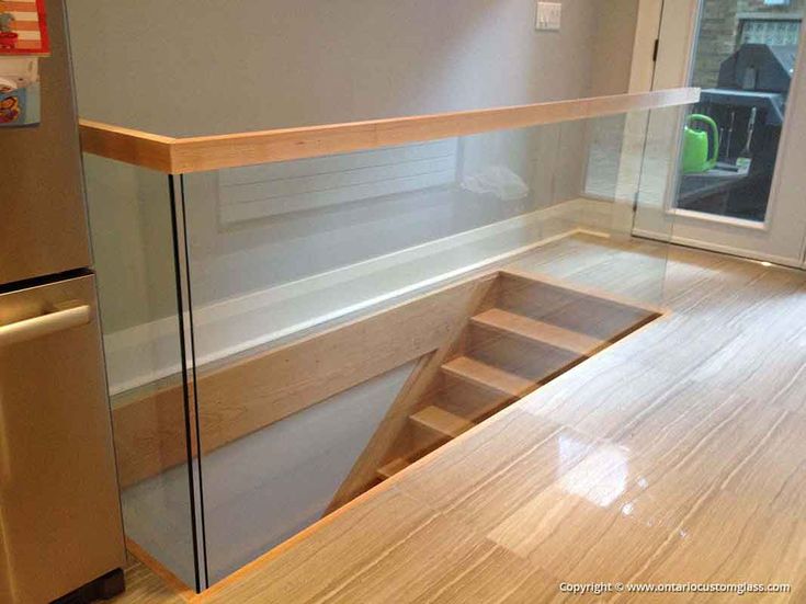 an empty kitchen with wooden flooring and stainless steel appliances