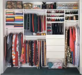 an organized closet with clothes, shoes and other items in it's storage area