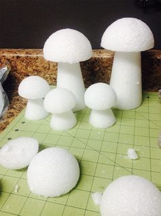 some white mushrooms sitting on top of a green cutting board