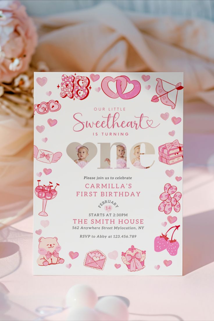 a pink and white birthday card with hearts on it, sitting next to some flowers