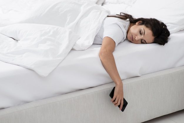 a woman laying on top of a white bed