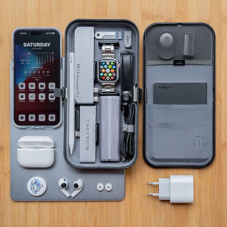 an apple watch and other electronics in a case on a wooden table with earbuds