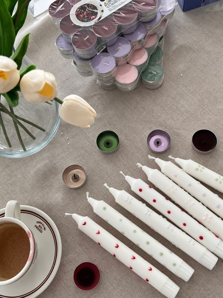 some candles are sitting on a table next to flowers