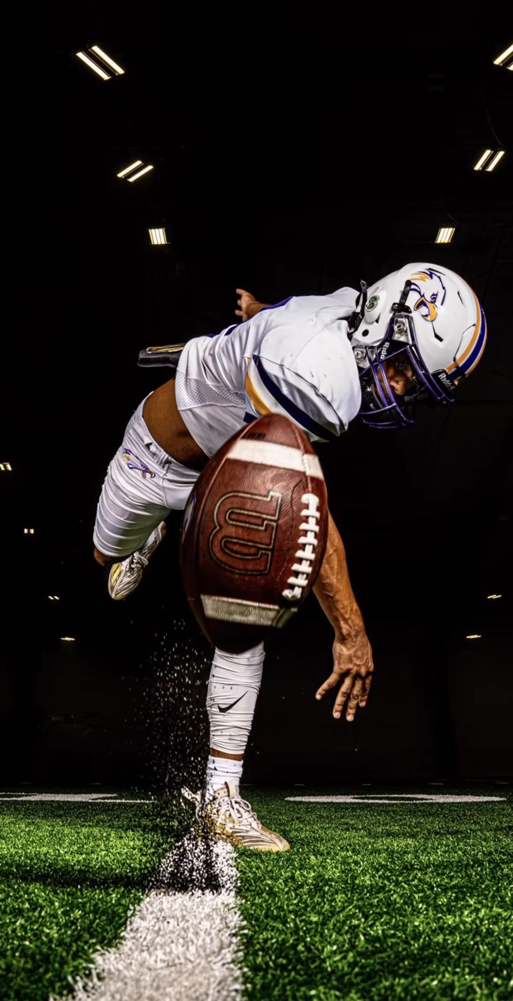 a football player jumping into the air with his foot on top of a football ball