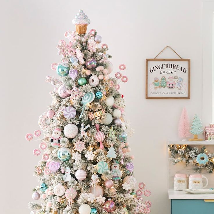 a white christmas tree with pink, blue and green ornaments