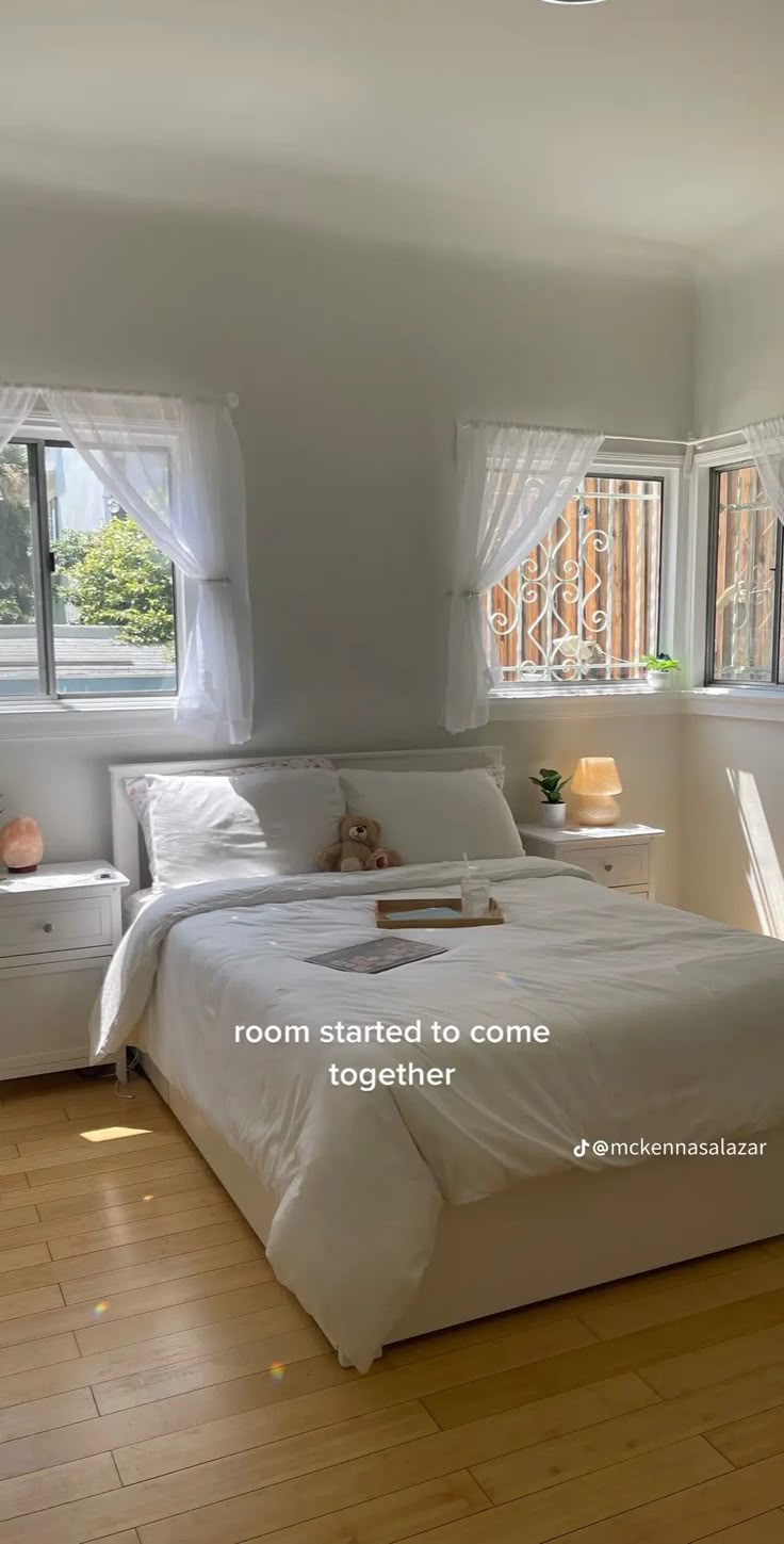 there is a bed in the room with white linens on it and two windows