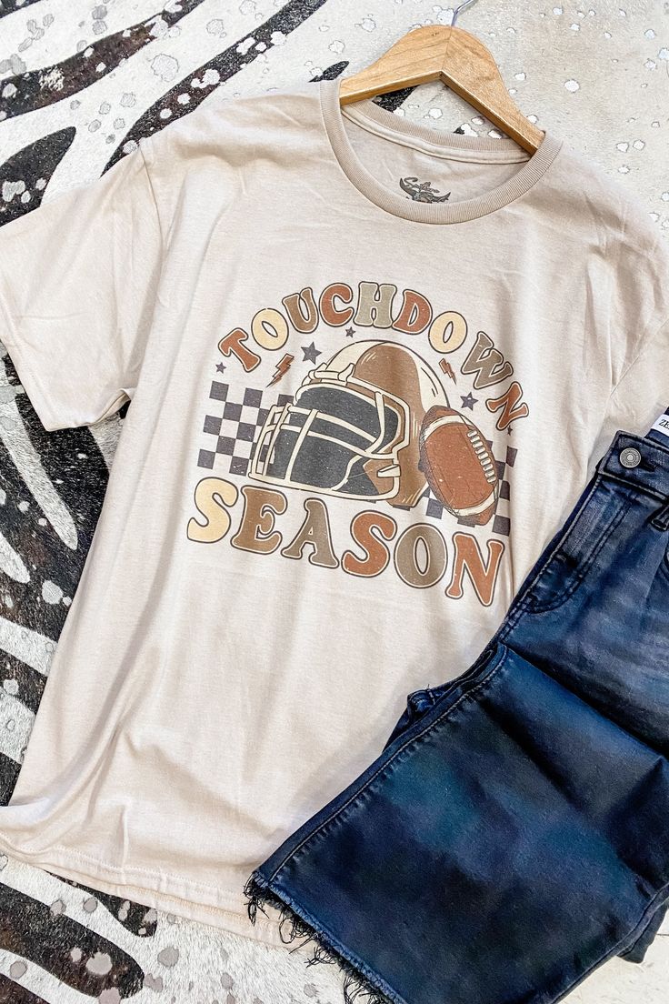 Get ready for touchdown season with our Checkered Football Season Graphic Tee! This retro-inspired tee features a bold football graphic and checkered design, perfect for showing off your love for the game! Add some sporty and nostalgic vibes to your wardrobe with this must-have tee. 52% cotton, 48% polyester round neckline unisex fit Southern Roots Boutique112 W Main St Paragould, AR *Please allow 5-7 business days processing time for this item to be shipped/picked up. Retro Relaxed Fit Tops For Game Day, Retro Tops For Streetwear During Football Season, Retro Fall Tops For Fan Merchandise, Fall Team Spirit T-shirt For Streetwear, Retro Fan Merchandise Tops For Fall, Retro Tops For Sports Season Fan Gear, Sporty Screen Print T-shirt For Fall, Retro Fan Gear Tops For Sports Season, Team Spirit T-shirt For Streetwear In Fall