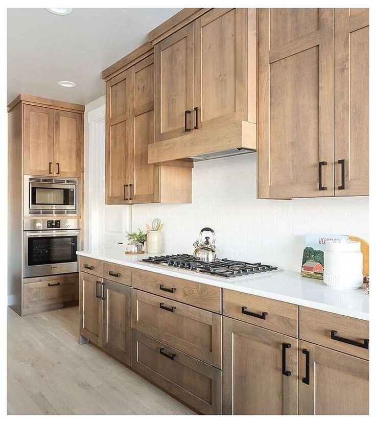 a kitchen with wooden cabinets and white counter tops