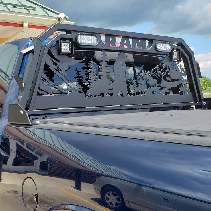 the back end of a pickup truck with mountains and trees on it's windshield