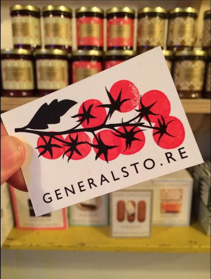 a person holding up a business card in front of some shelves with sodas and cans