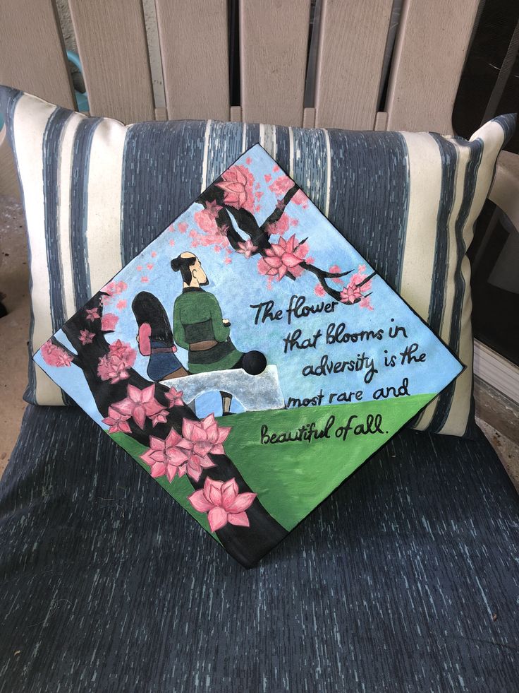 a decorated graduation cap sitting on top of a blue chair next to a striped pillow