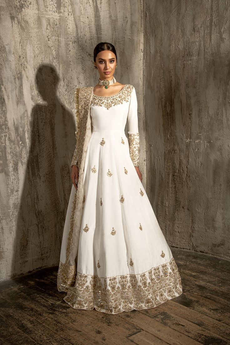 Royal Nikkah Dress for Bride in Pishwas Style is the epitome of tradition and royalty. Hand-crafted details and perfect stitching of this Pishwas Dress make it your foremost priority to wear on the most important day of your life to have your stunning dreamy look. Pishwas: Pakistani Bridal Dress in the alluring white shade is an exquisite masterpiece for the gorgeous bride. This Traditional Pishwas attire is hand-embellished with zari, tilla, dabka, and resham details. Embellished borders, neckl Nikkah Dress For Bride, Dress For Bride, Pakistani Bridal Dress, Nikah Dress, Desi Dress, Desi Wedding Dresses, Nikkah Dress, Asian Bridal Dresses, Pakistani Wedding Outfits