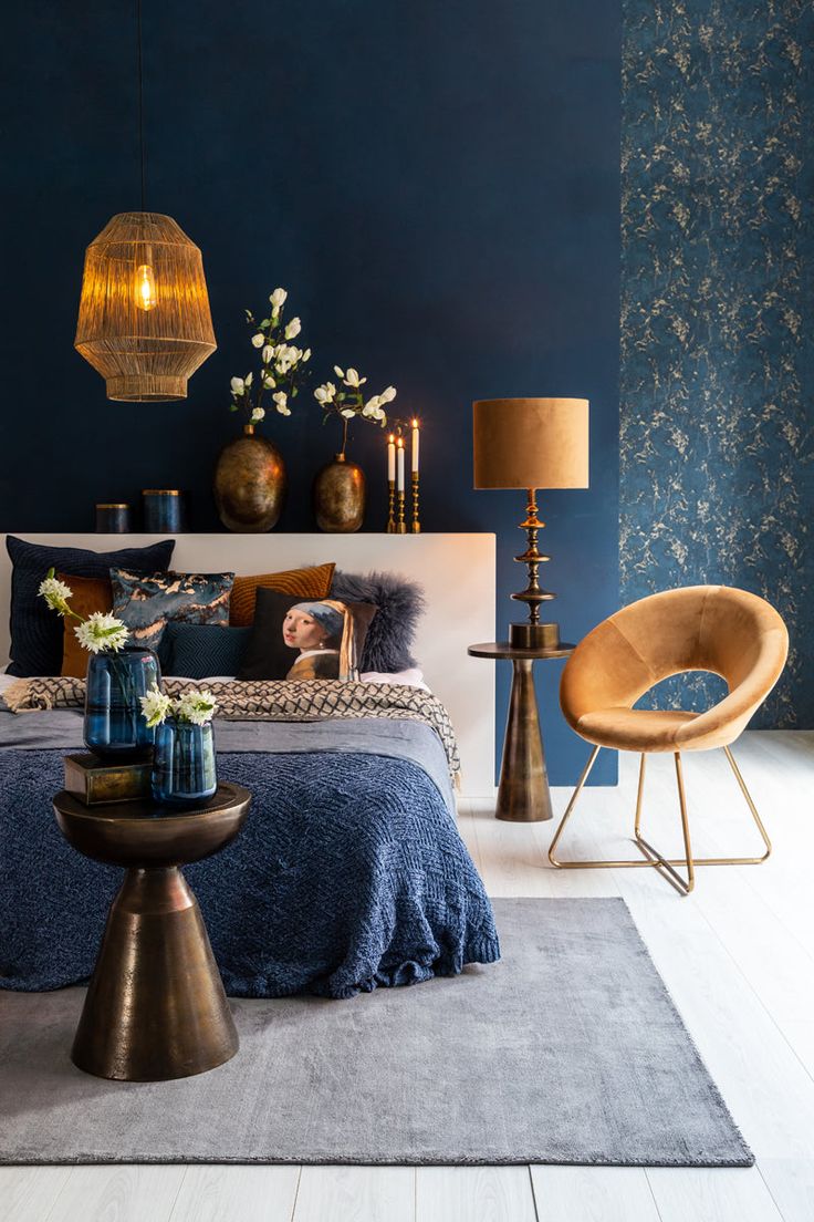 a bedroom with blue walls and gold accents