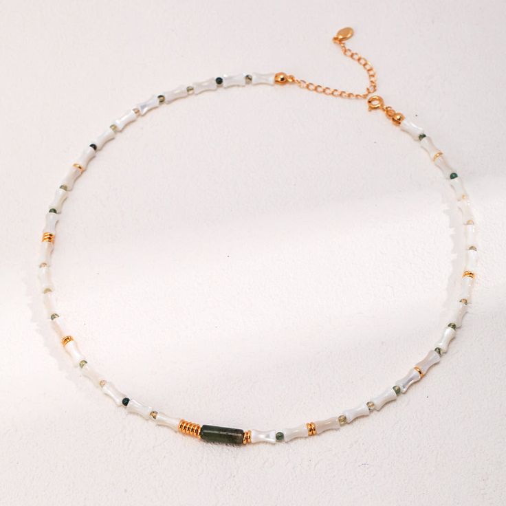 Wear the charm of mother-of-pearl with the organic elegance of bamboo-inspired beads and a Moss Agate bead in the middle. Each segment is crafted with precision, reflecting a dedication to the art of jewelry making and a tribute to natural beauty. Gemstone Type: Moss Agate, Mother-of-Pearl Length: 36.5cm+6cm Material: 18k Gold Plated on Sterling Silver Note: Every pearl is unique. Items may vary from the pictures. Bead Choker, Beaded Choker, Agate Beads, Unique Items, Polish Jewelry, Moss Agate, Natural Pearls, Pearl Jewelry, In The Middle