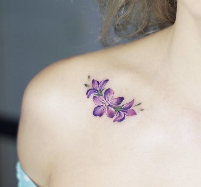 a woman with a purple flower tattoo on her shoulder