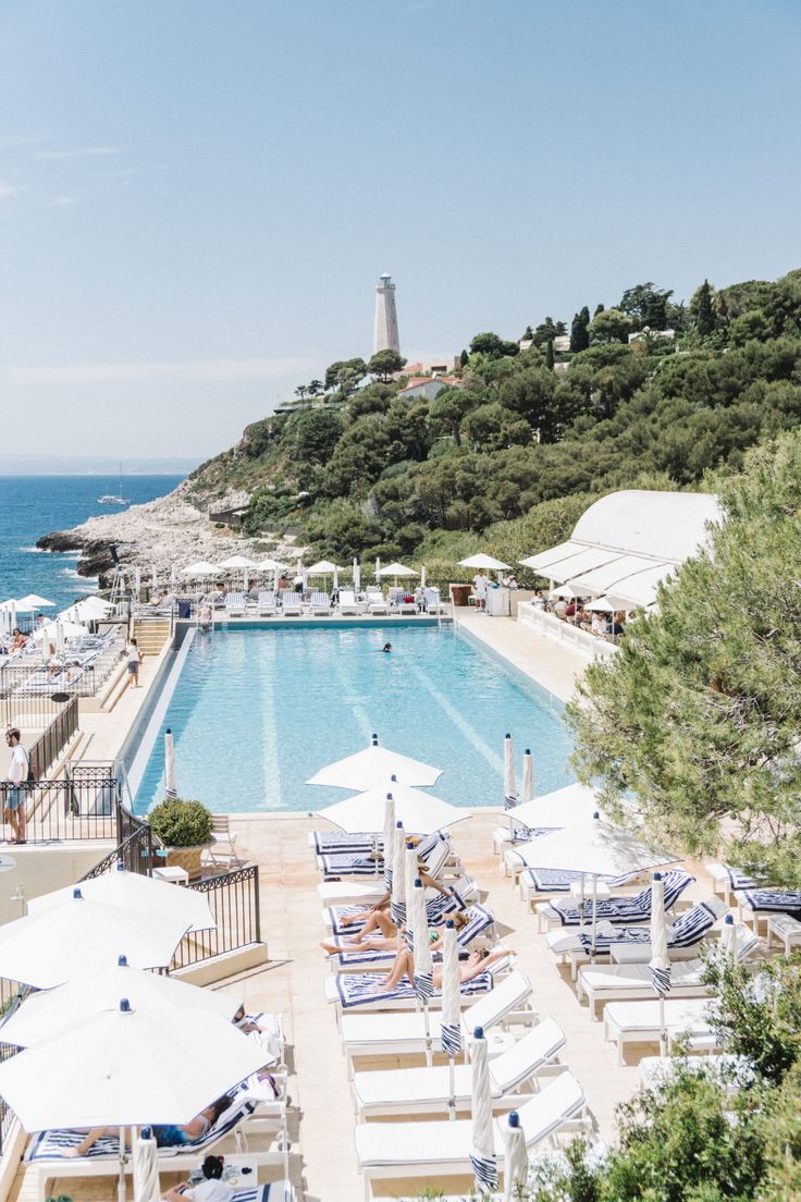 an outdoor swimming pool next to the ocean