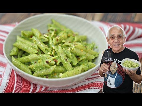 an old man holding a bowl of green beans and a bottle of beer next to a bowl of food