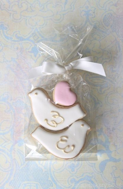 a decorated cookie in the shape of a bird with a pink heart on its back