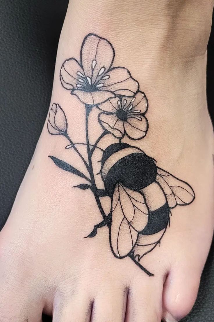 a foot with a bee and flowers on it